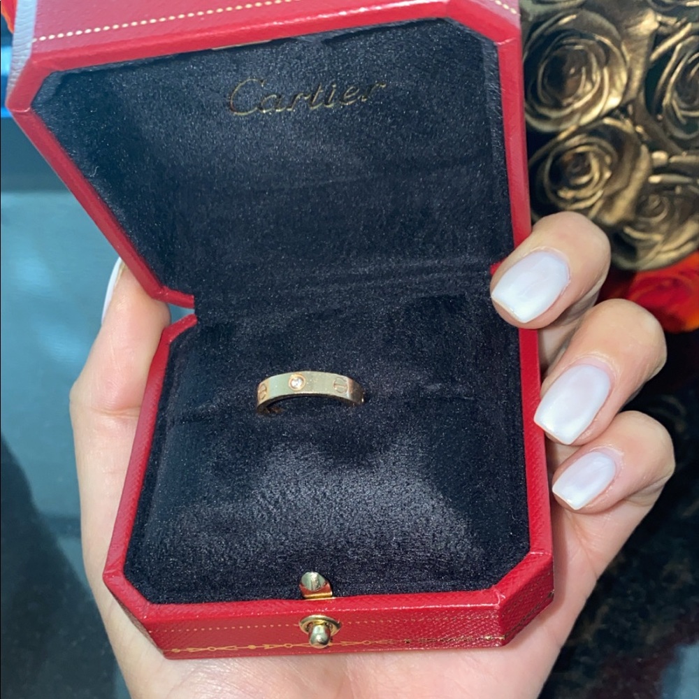 Rose gold cartier love ring with one diamond.